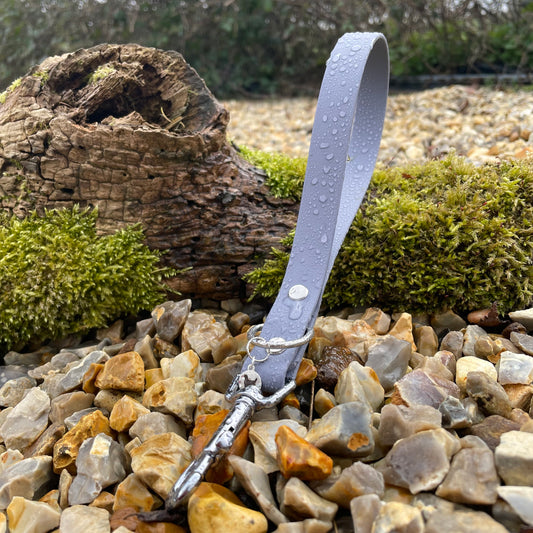 Our traffic handle in Ash Grey BioThane®, pictured on a bark branch surrounded with green moss to show off the colour