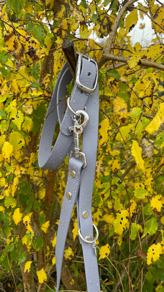 Ash Grey BioThane® collar, pictured on a bark branch surrounded with green moss to show off the colour