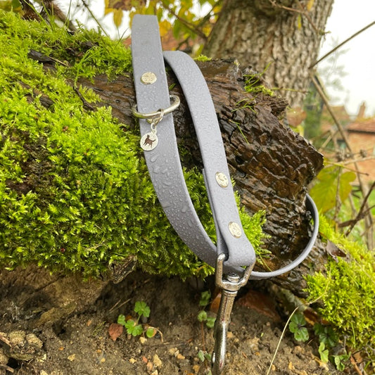 Our standard 1-metre Ash Grey BioThane® lead, pictured on a bark branch surrounded with green moss to show off the colour