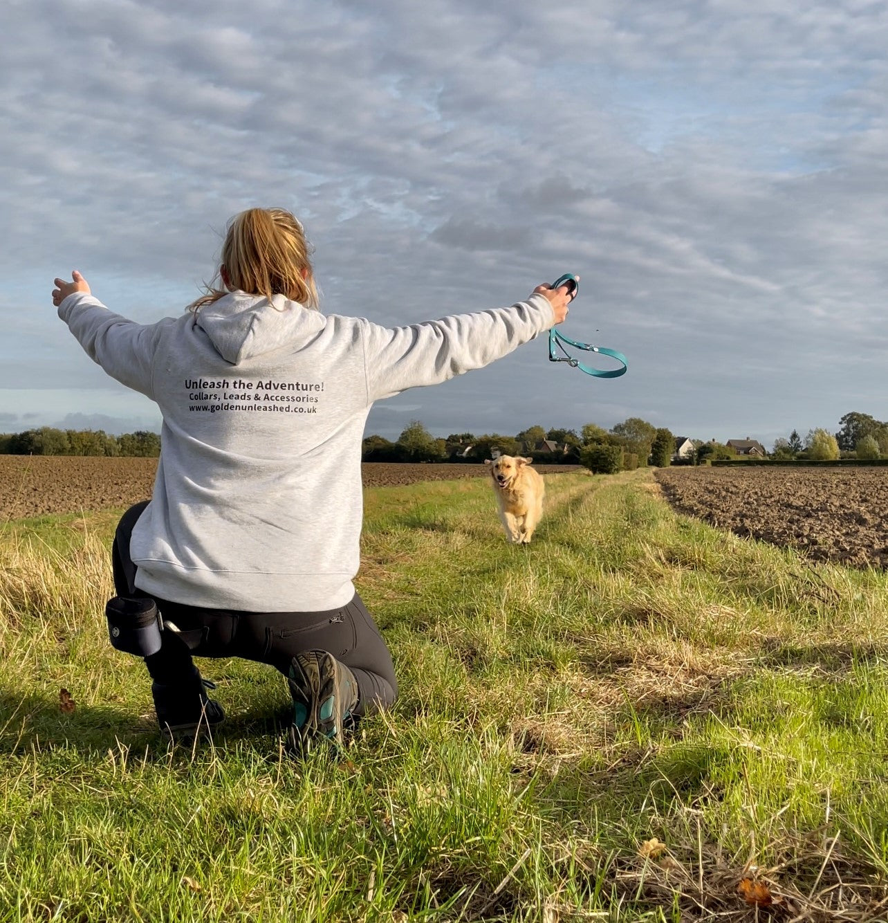 Golden retriever Blueberry running towards his owner who is knelt down with arms wide open ready for the embrace
